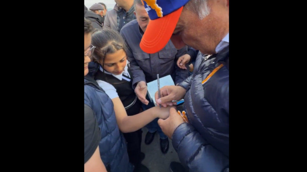 Փաշինյանը ստորագրեց դպրոցական աղջկա ձեռքին